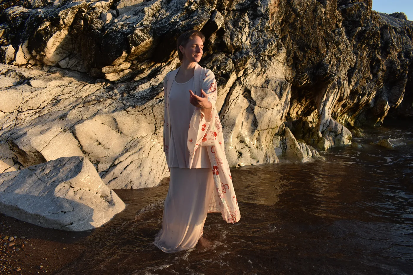 Femme debout dans l'eau au bord des rochers